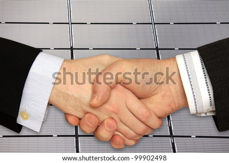 Businessmen shaking hands in front of the Solar Power Station