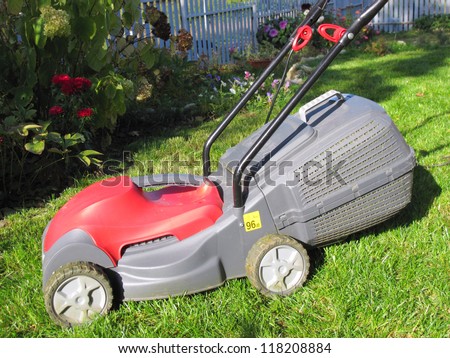 Modern electric lawn mower on the mown down lawn