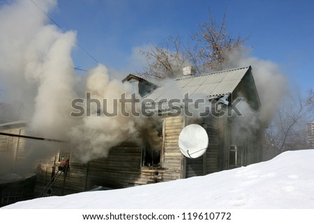 Private house in the fire puffs against a blue sky in the winter
