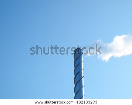 Steel smoking stack of the modern boiler-house against a blue sky