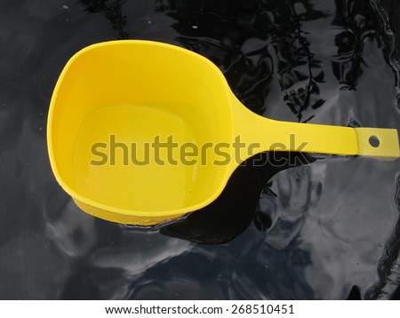 Plastic water dipper floating in the barrel