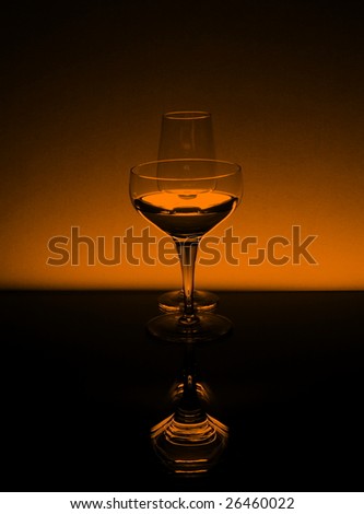 Tall wineglasses in black and orange against an orange background