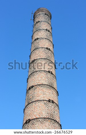 Old brick stack of boiler house against a blue sky