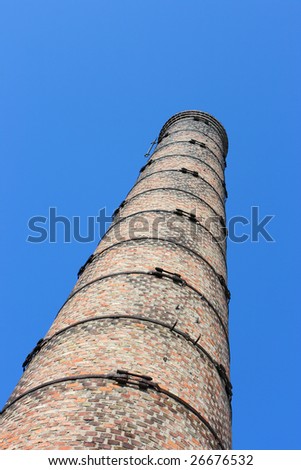 Old brick stack of boiler house against a blue sky