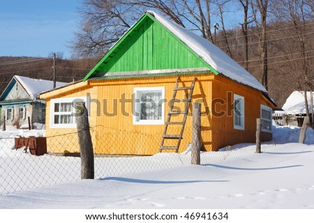 Summer wood cottage against a blue sky in the winter