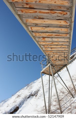 Stairs with landing against a snow slope