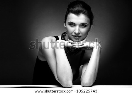 Black and white portrait of beautiful woman  in black dress with pearl necklace