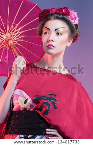 Fashion asian woman wearing traditional japanese red kimono with umbrella, studio shot. Geisha