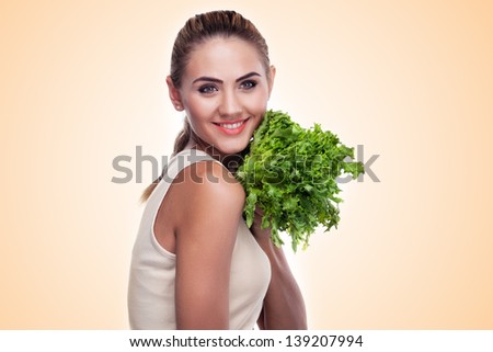 Close-up portrait of happy young woman with bundle herbs (salad) in hands on white background. Concept vegetarian dieting - healthy food