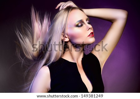 Fashion studio shot of beautiful woman in violet dress with Professional makeup and hairstyle