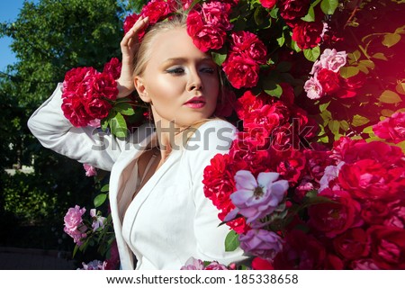Beauty woman with bunch rose flowers. Professional Makeup and hairstyle