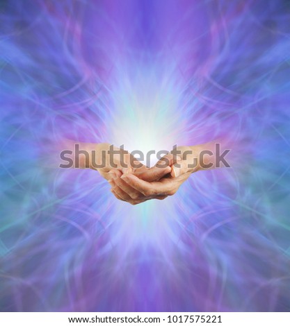 Sacred Purple Ray Healing Energy - female hands  emerging from a purple energy background making cupped hands gesture with a bright light behind and plenty of copy space