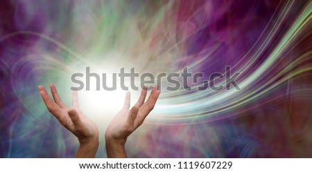 Stunning Healing Energy phenomenon  - female hands reaching up into a ball of white  energy with a laser trail and pink green ethereal energy field  background