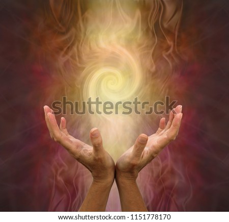 Channeling Golden Vortex healing energy  - female hands held open and palms upwards with a vortex energy formation above on a warm golden brown background