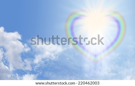 Heart shaped rainbow with bright star burst breaking through on a blue sky and fluffy cloud background