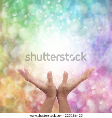 Rainbow healing energy on bokeh background  -  Female healer\'s hands outstretched open with a beautiful sparkling rainbow colored bokeh background