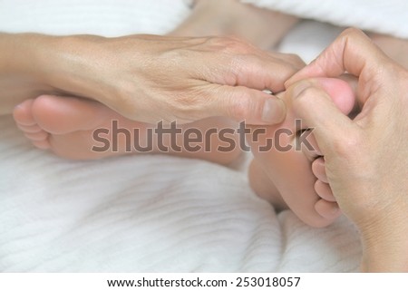 Close-up of reflexologist working on woman\'s big toe