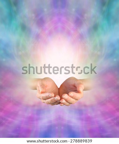 Sending Divine Healing Energy -  Female cupped hands on an ethereal pink and blue energy formation background with a burst of white light rising up and plenty of copy space
