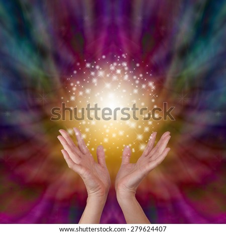 Magical healing energy on radiating color background - Female healer\'s hands outstretched open with a beautiful sparkling ball of golden light above on a deep colored energy formation background