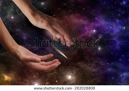 Make a wish on a shooting star - Colorful outer space background with stars and planets and a pair of female hands appearing to be reaching for a shooting star and plenty of copy space on right side