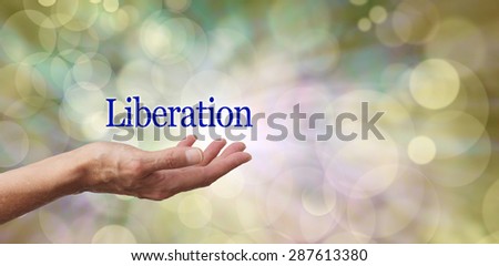 Celebrate Liberation - Female hand outstretched with the word \'Liberation\' floating above on a neutral toned bokeh effect background