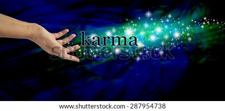 Creating Karma - Female hand outstretched with the word \'Karma\' floating away amongst a stream of sparkles on a dark blue swirling background with a swirl of green light behind the glitter