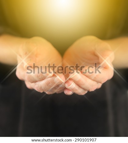 Healer with Golden Healing Orb Energy - female holding hands in cupped position with a bright golden orb  energy hovering above and sparkles around finger tips