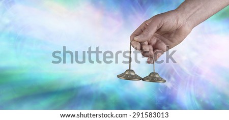 Ting Sha sound vibrations - Male Sound healer holding Ting Sha percussion bells against a blue background with white light depicting sound vibrations