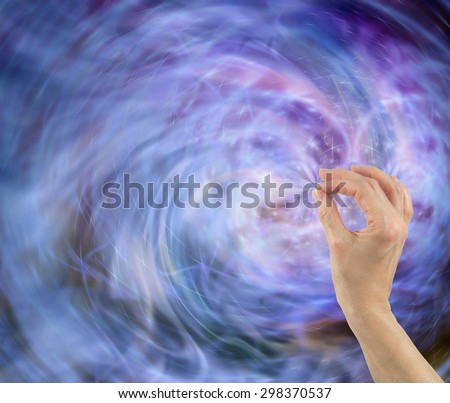 Cause and Effect - Female hand in bottom right corner appearing to influence energy field of blue white and black particles with plenty of copy space