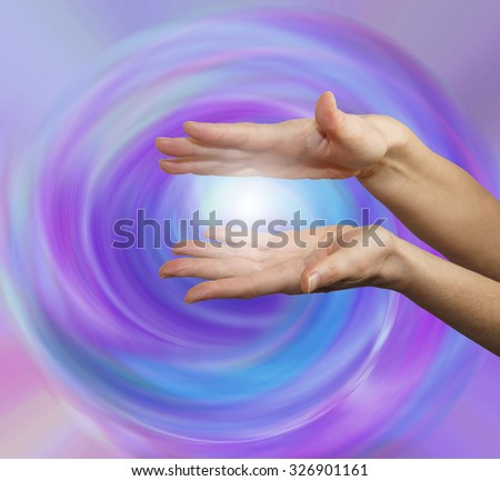 Vortex Healing Energy -  Parallel female hands with ball of white light between on a purple pink blue spiraling vortex energy field background