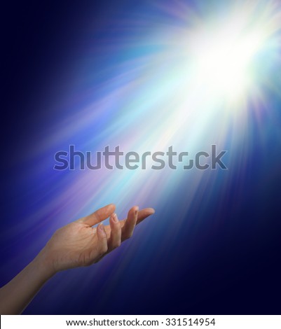 Seeking Spiritual Guidance    Female hand reaching upwards into a bright energy burst  with subtle rainbow color strands with plenty of copy space
