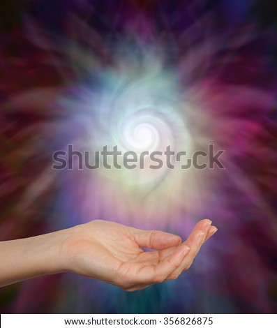 Sensing Spiral Energy  -  Female hand outstretched palm up gently cupping a beautiful ethereal spiraling energy formation