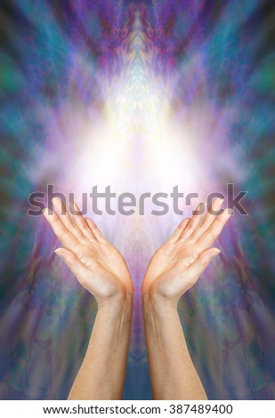Goddess Healing Energy - a pair of female hands reaching up towards a beautiful angelic light form on a multi colored blue and purple background with plenty of copy space
