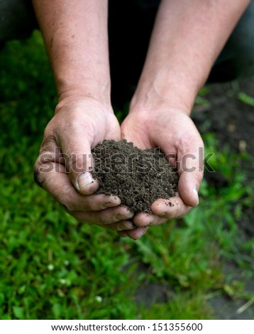 Gardener\'s hands holding dirt