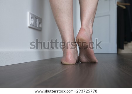 Woman legs walking on wooden floor