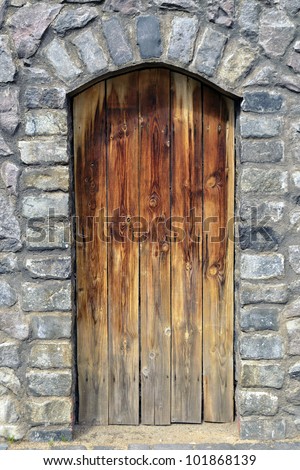 old time wooden door in medieval stone wall
