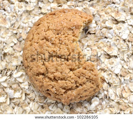 bitten oat cookie over oat flakes background