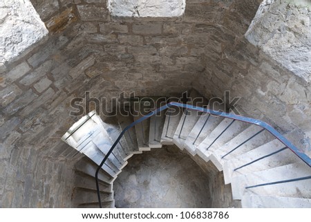 concrete spiral stairs with metallic handrails go down