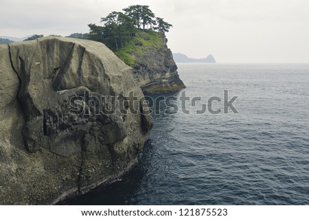 Huge rocks formation shoreline with scenic pine trees on the cliff top on Izu Peninsula in Japan