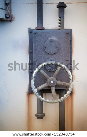 rusty iron lock on the harbour warehouse door; focus on the wheel and lock\'s body
