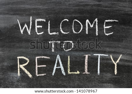 welcome to reality phrase handwritten on the school blackboard