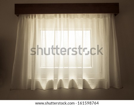 transparent curtain with small window behind taken from room interior