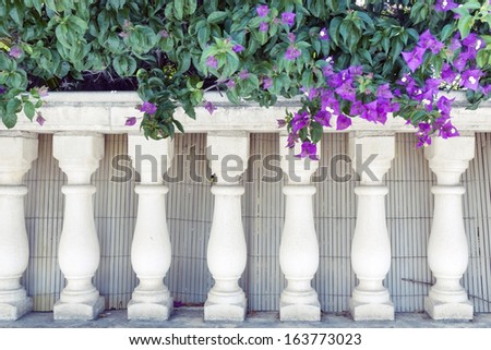 fragment of small pillars fence decorated by blossom flowers