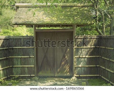 traditional straw fence and old wooden gate in Japanese zen garden