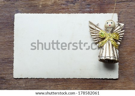 wooden table with vintage post card and toy angel figure