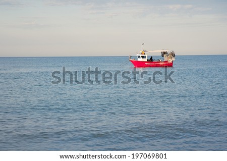 red fishing boat in the blue morning sea