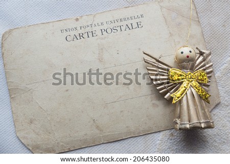 blank vintage postcard with toy angel figurine