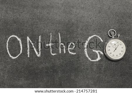 on the go phrase handwritten on chalkboard with vintage precise stopwatch used instead of O