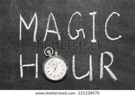 magic hour concept handwritten on chalkboard with vintage precise stopwatch used instead of O