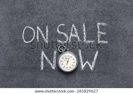 on sale now phrase handwritten on chalkboard with vintage precise stopwatch used instead of O